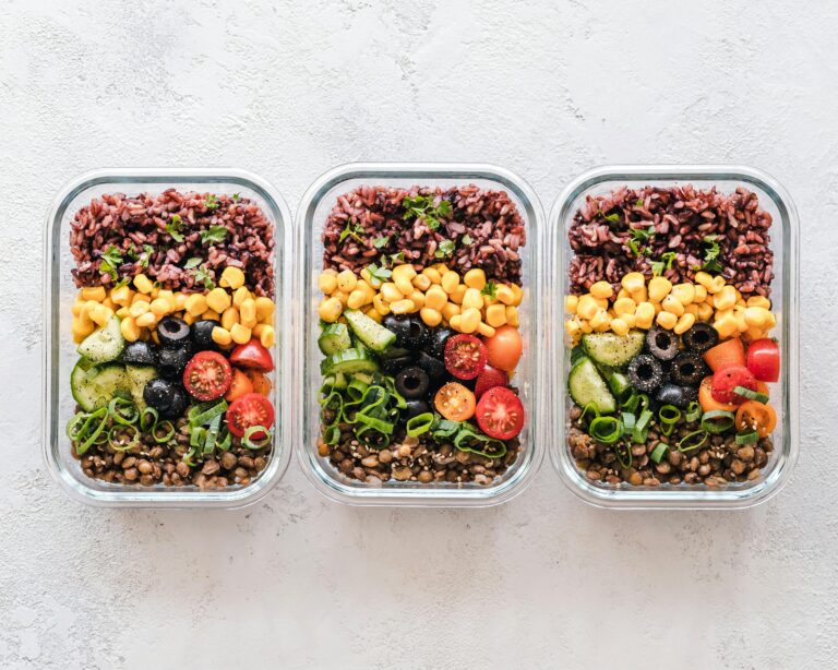 Colorful healthy meal prep with corn olives tomatoes and lentils in glass containers