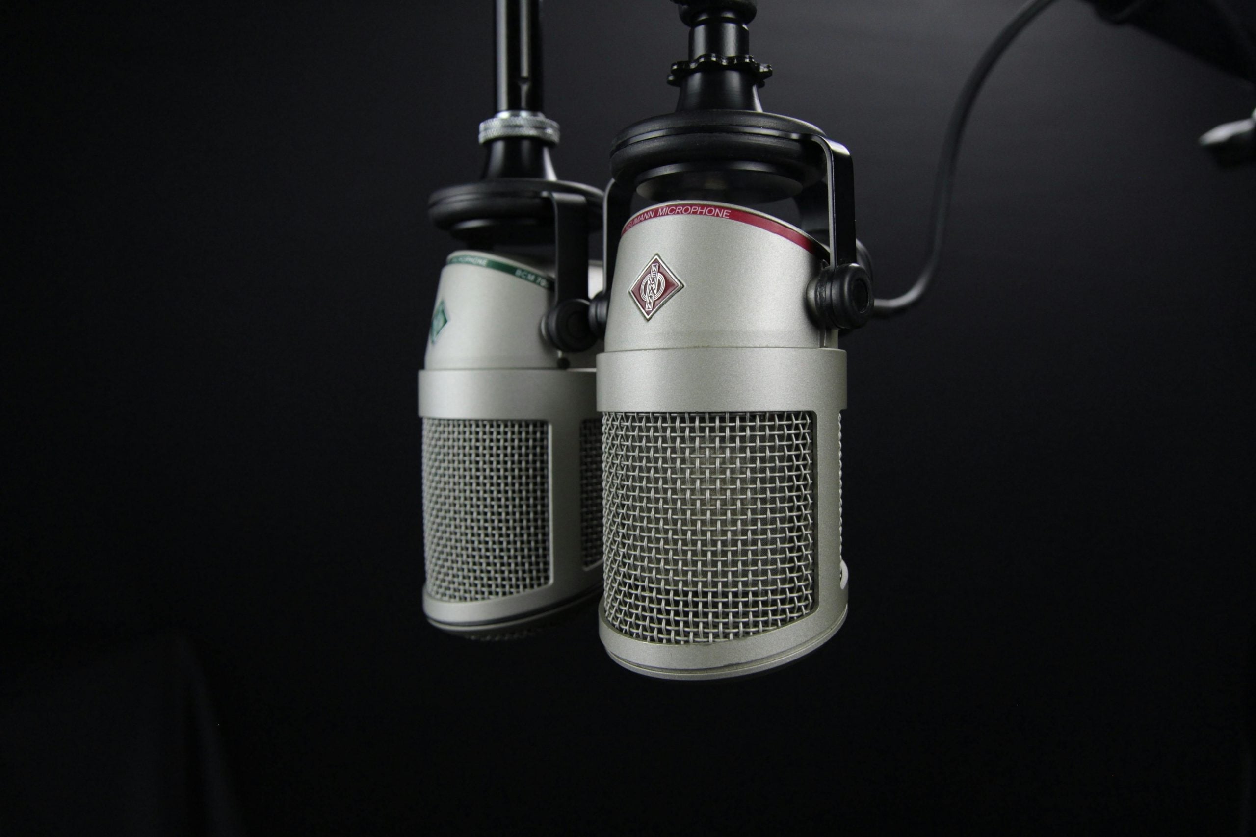 Professional studio microphones on dark background symbolizing focused communication