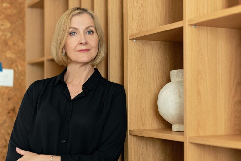 Confident businesswoman standing in office setting showcasing professional leadership.