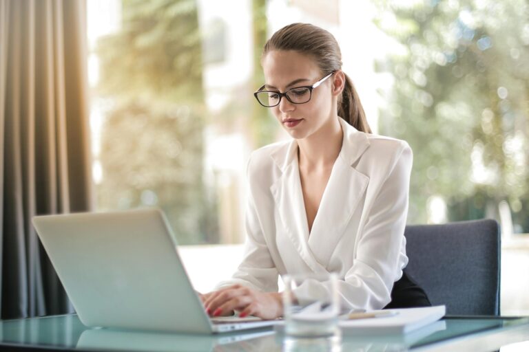 Confident businesswoman using laptop at desk focused on work