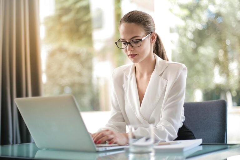 Confident businesswoman using laptop at desk focused on work