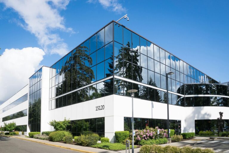 Contemporary office building in Redmond with reflective glass and lush green surroundings.