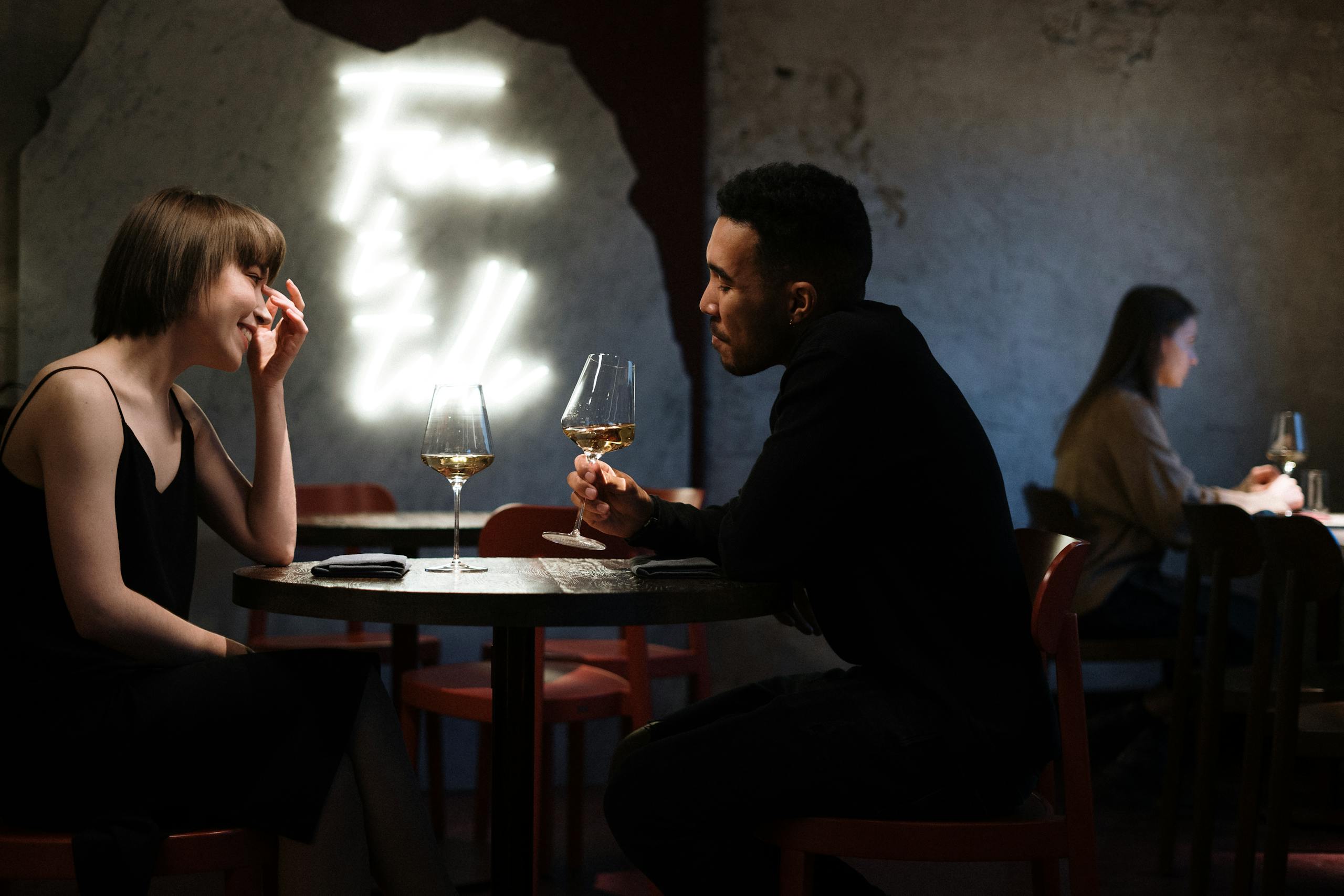 Romantic couple enjoying wine together in stylish bar setting