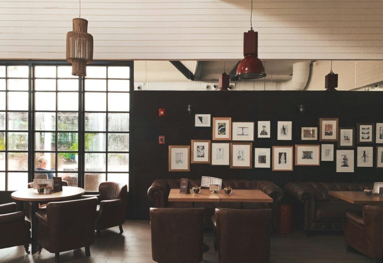 Cozy cafe interior with leather chairs, framed art, and pendant lighting