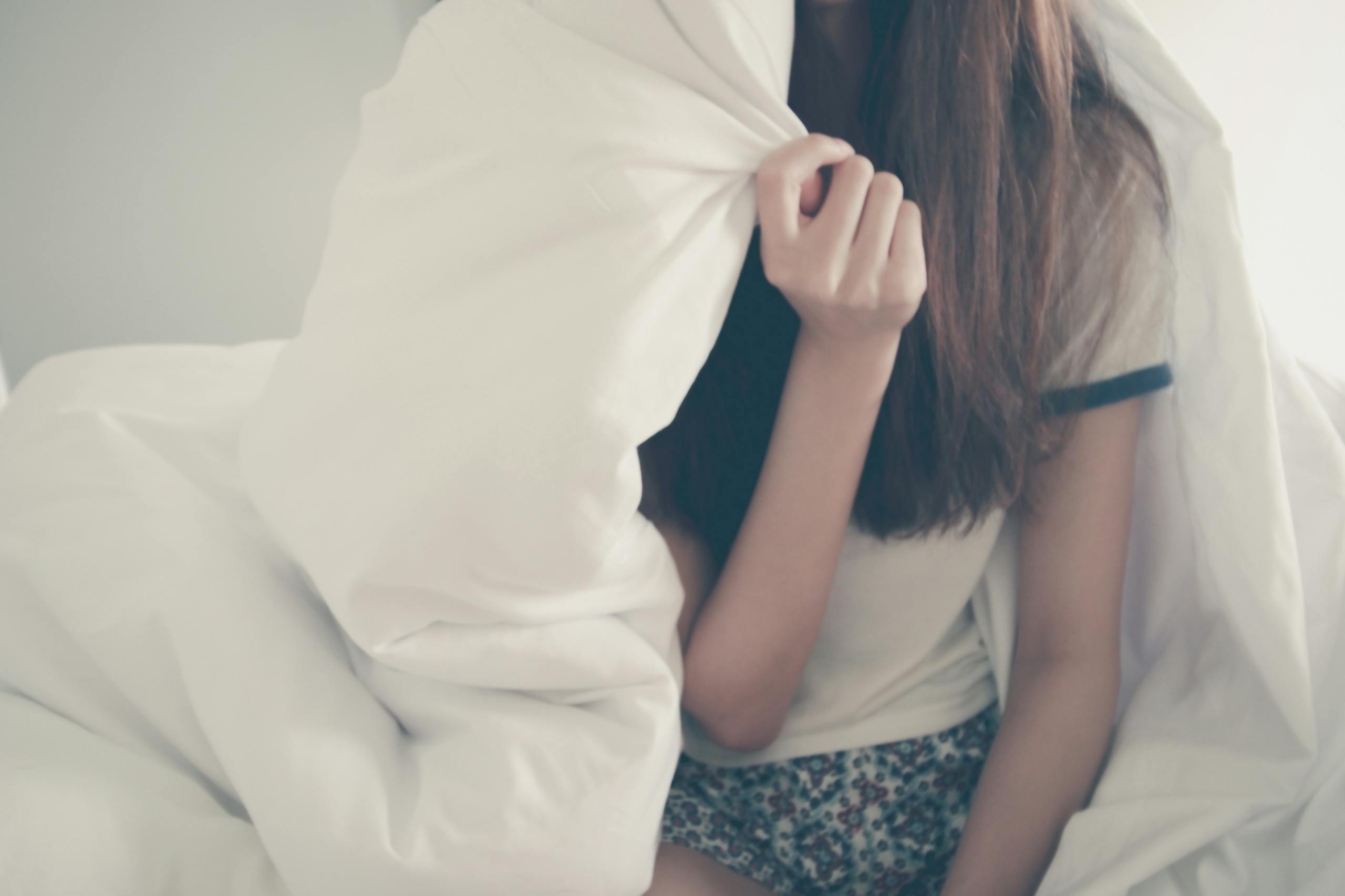 Young woman relaxing peacefully under cozy blanket in warm morning scene