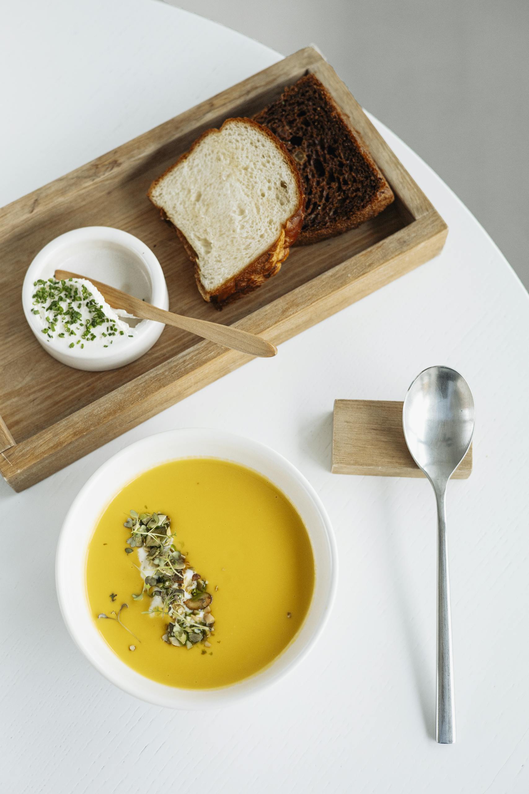 Delicious pumpkin soup with fresh bread and creamy dip for gourmet dining