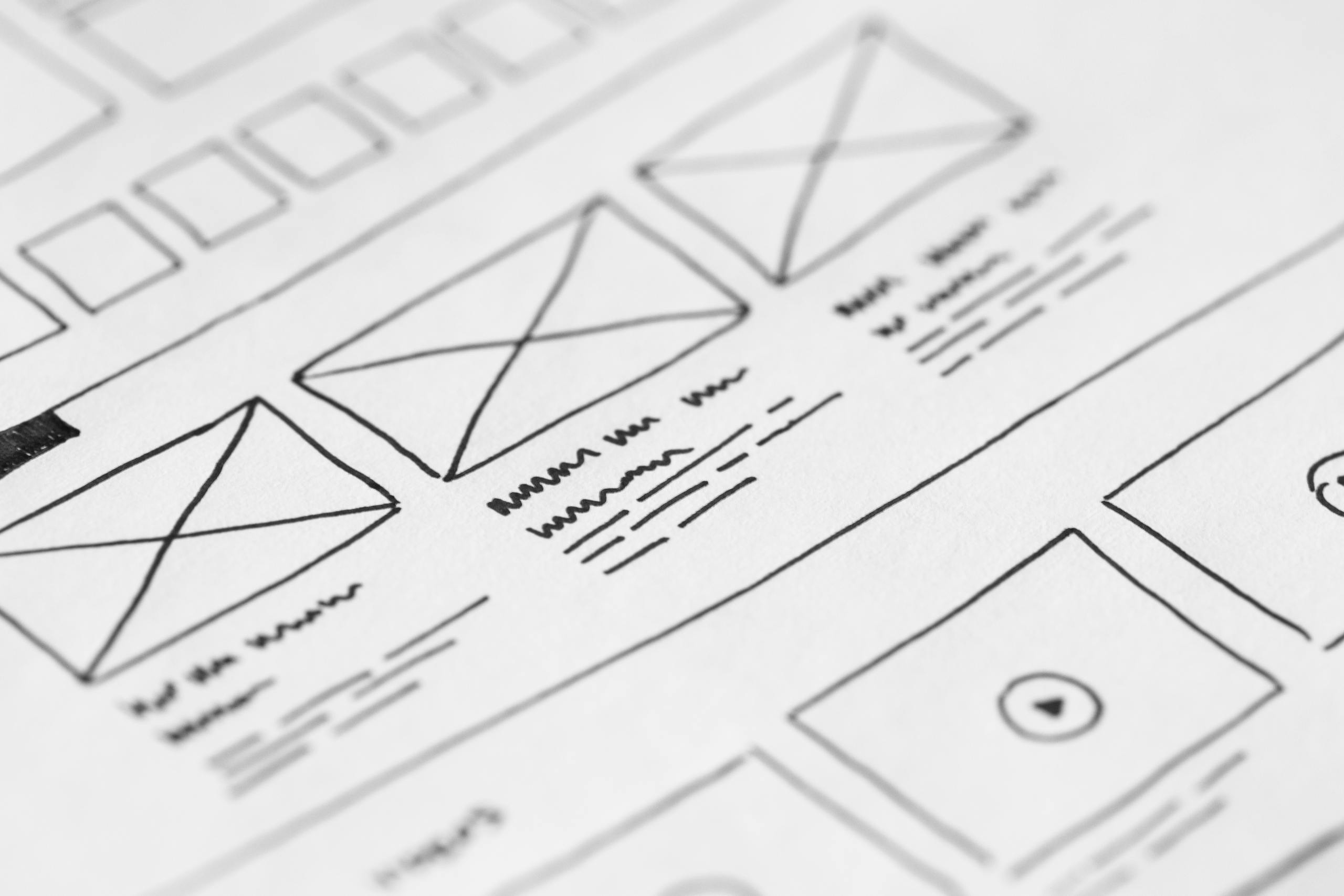 Detailed close-up of hand-drawn wireframe design sketches on paper for UX project
