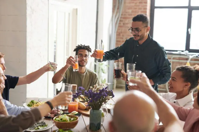 Group of diverse people toasting with colorful drinks at a social gathering