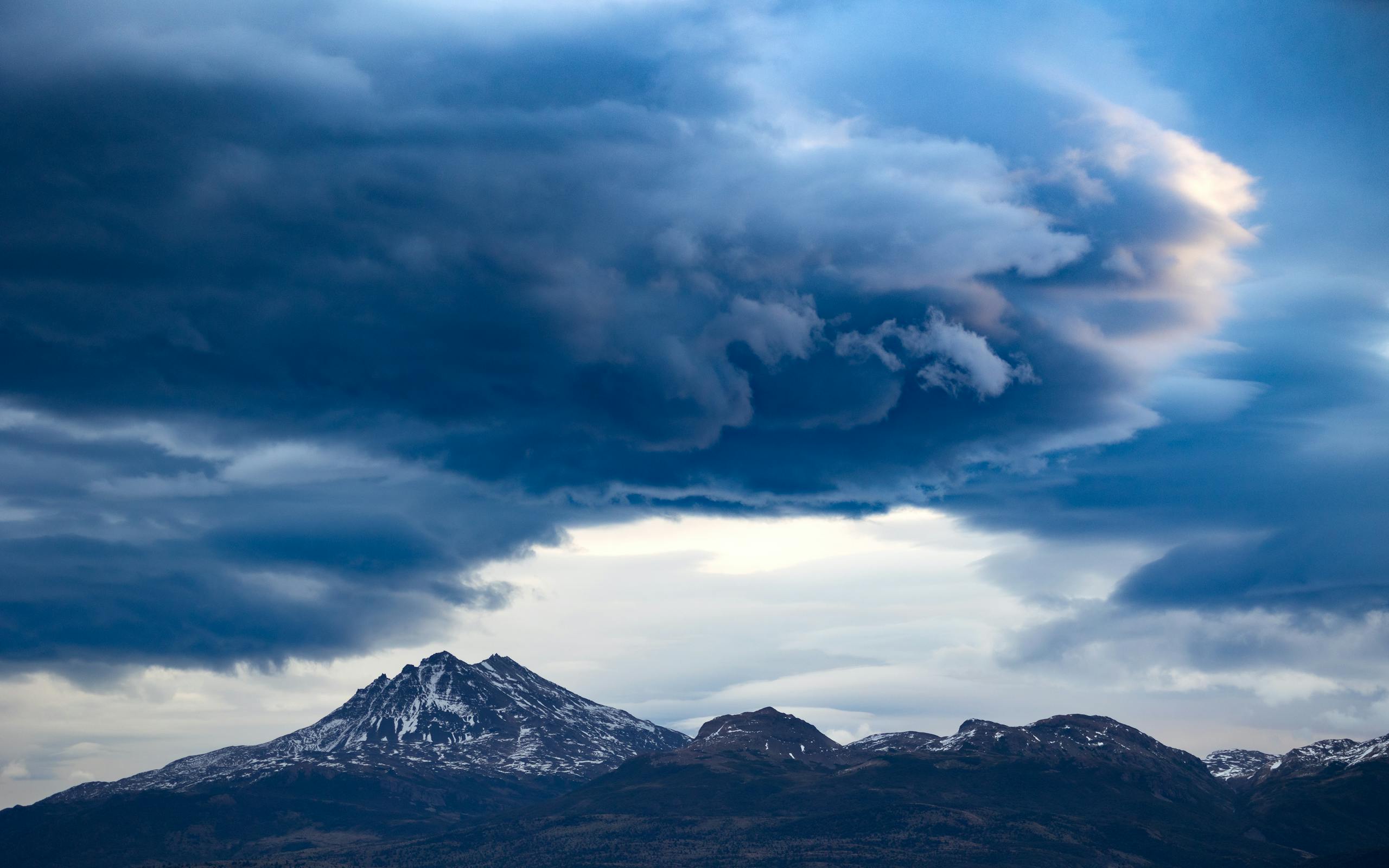 Epic dramatic clouds over snowy Patagonia peaks in Chile landscape.