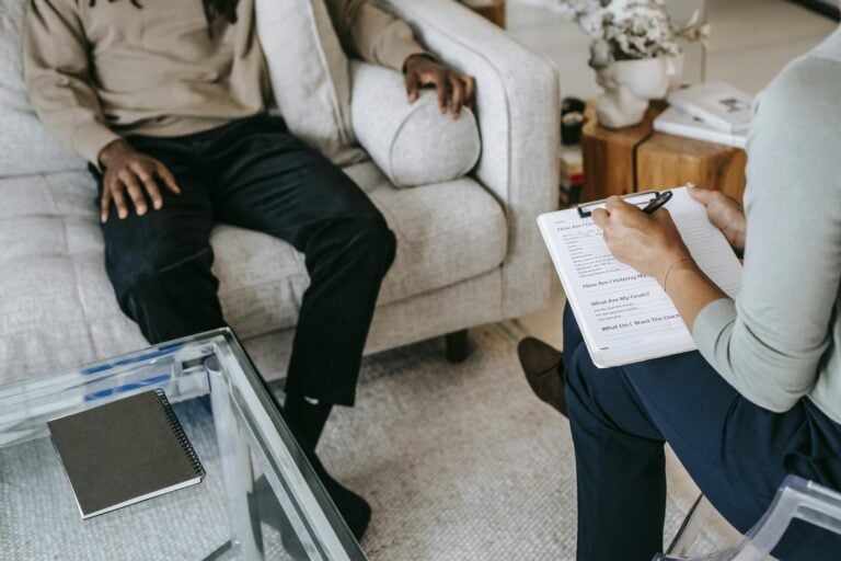 Male client discussing with female therapist during psychotherapy session from above angle