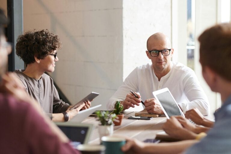 Group of professionals engaged in brainstorming session around table in contemporary office