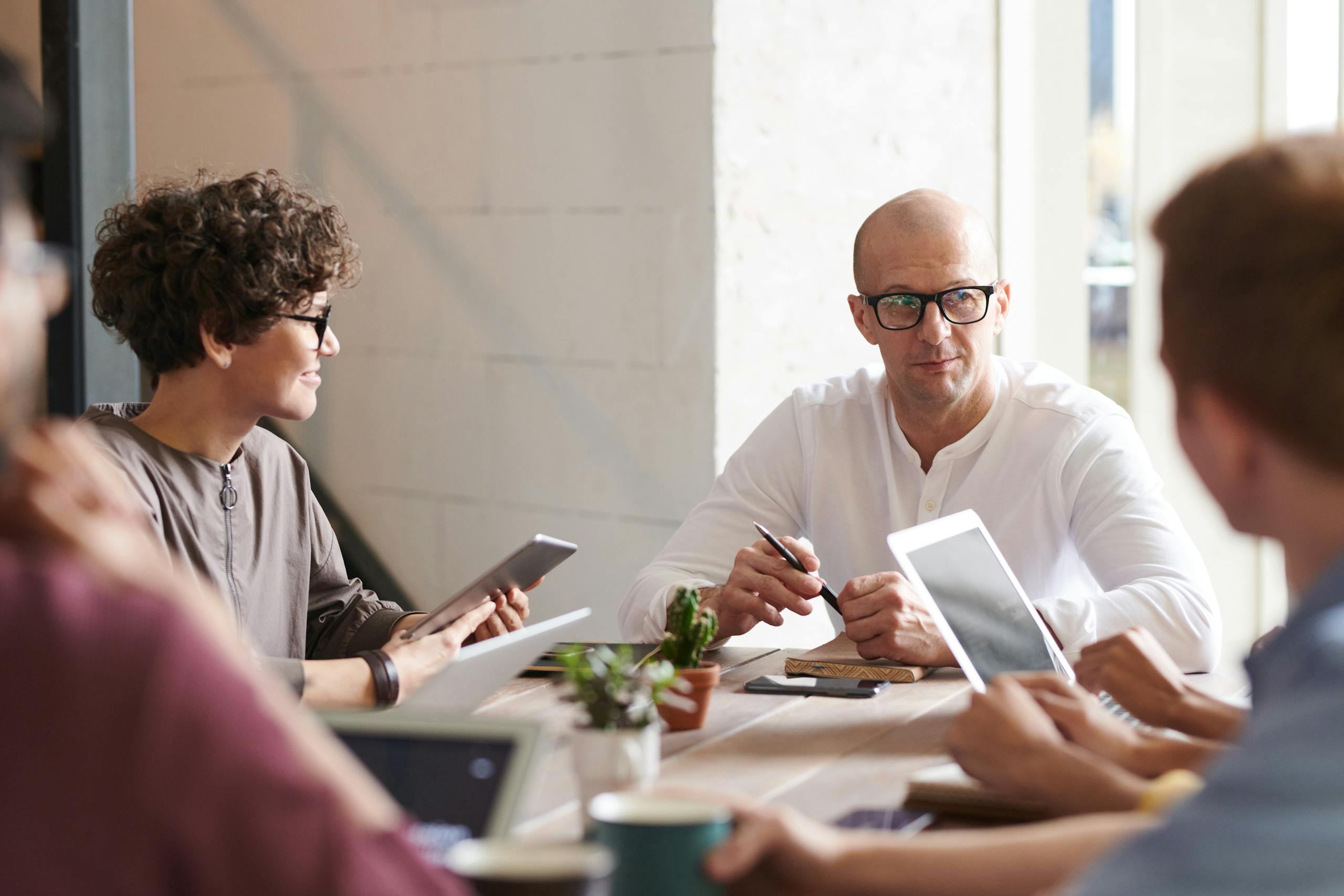 Group of professionals engaged in brainstorming session around table in contemporary office