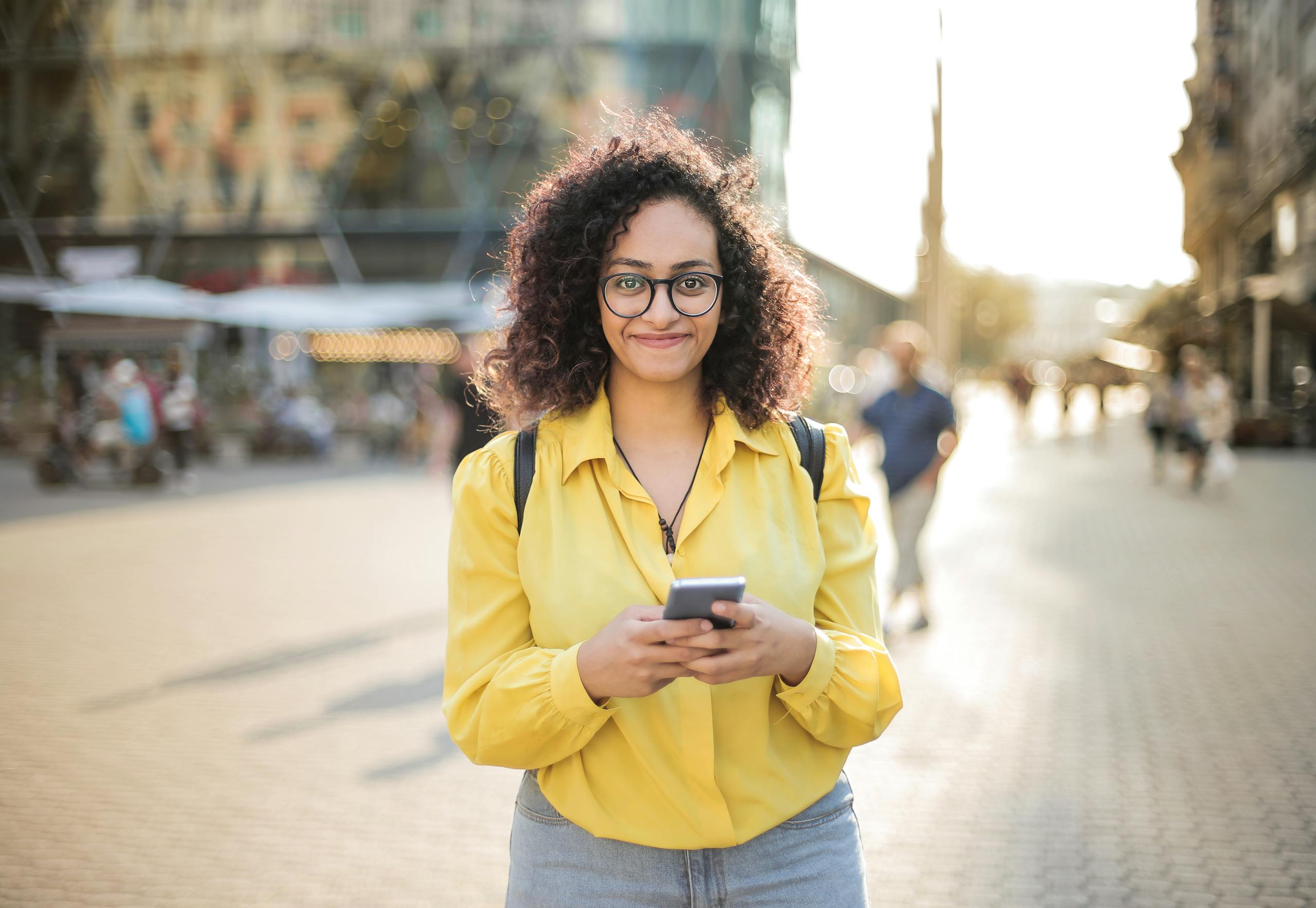 Person smiling while reading message from long-distance friend on phone
