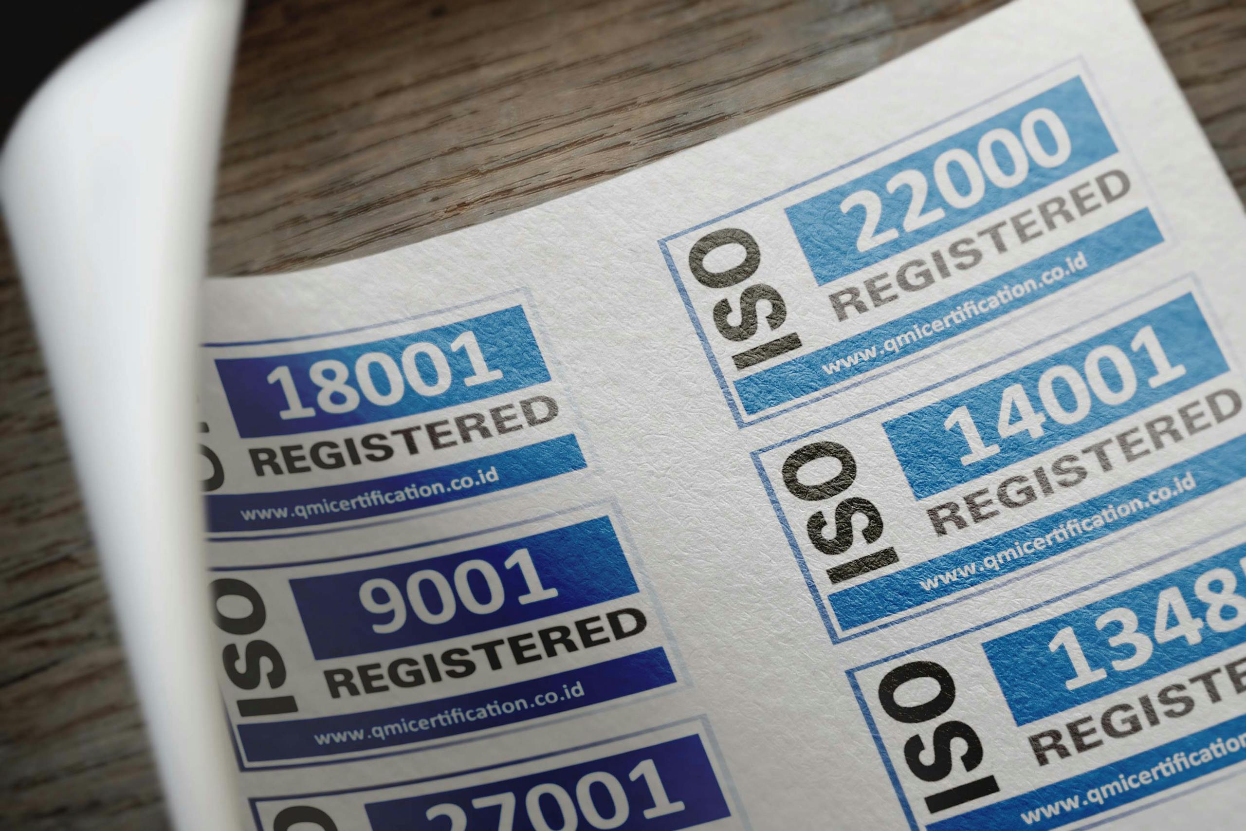 ISO certification stickers with registration numbers on paper documentation.