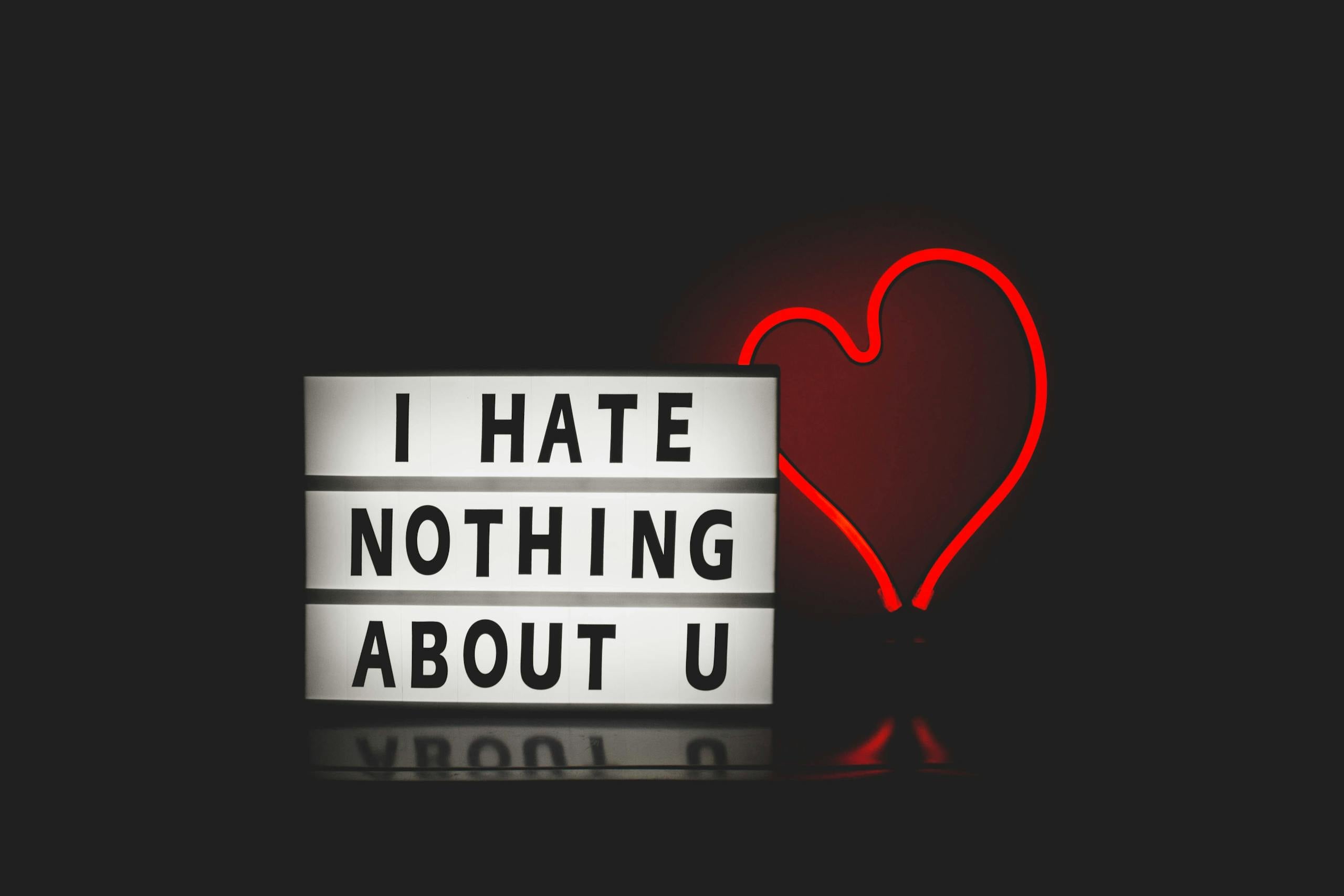 Neon heart lightbox message creating romantic atmosphere against plain background.
