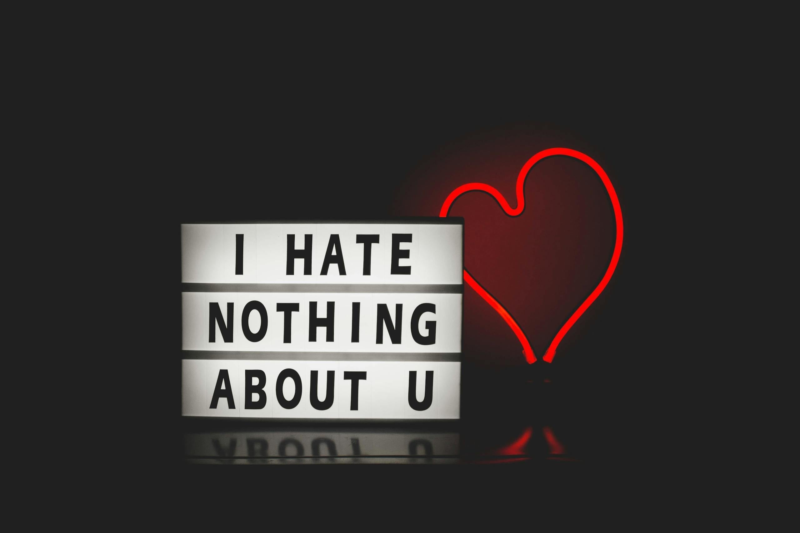 Neon heart lightbox message creating romantic atmosphere against plain background.