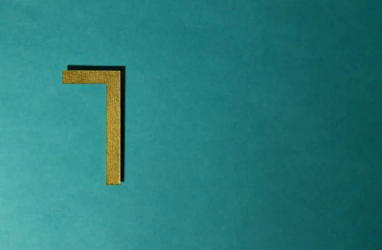 Minimalist golden numeral seven on teal background for decorative use