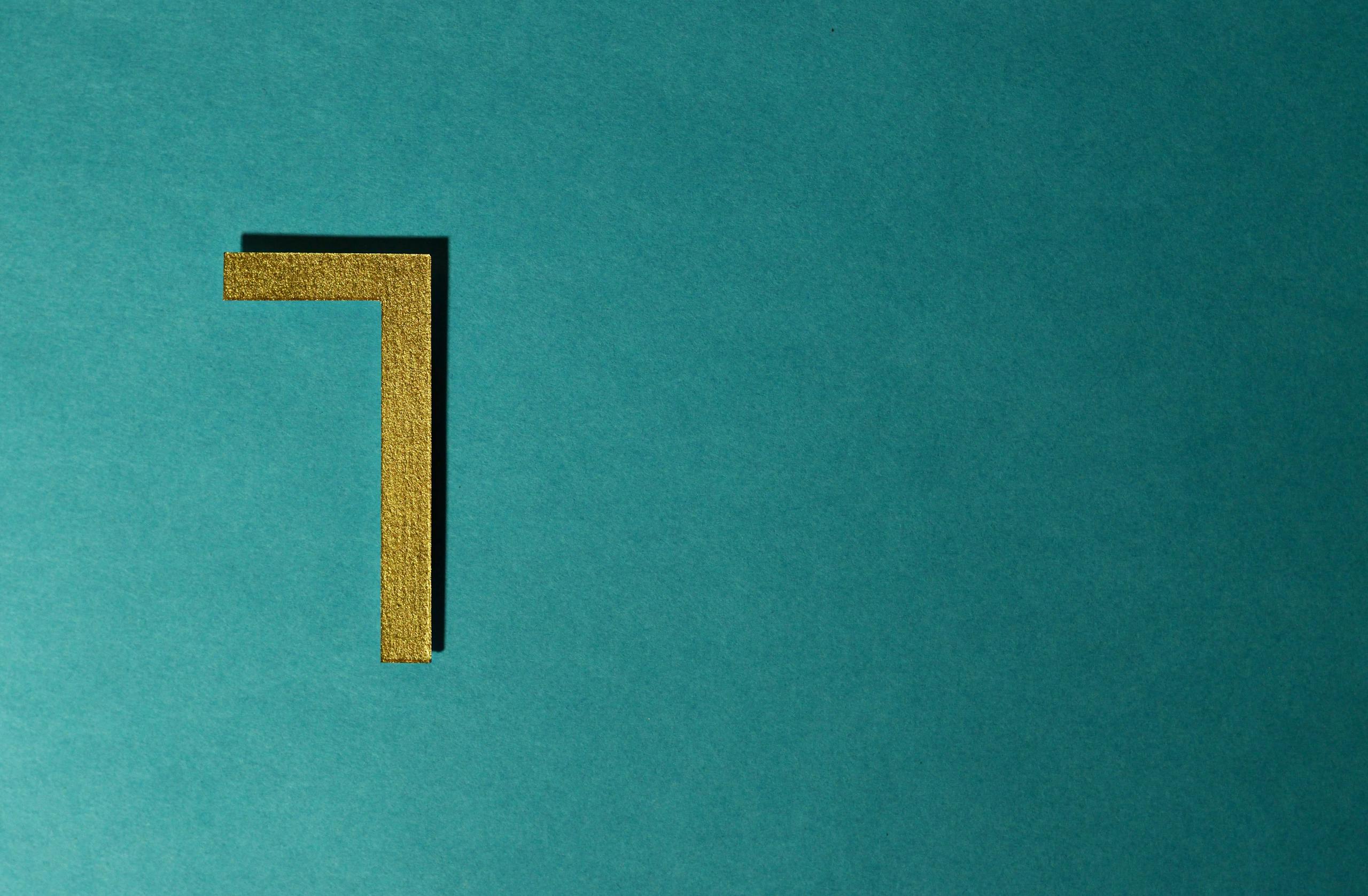 Minimalist golden numeral seven on teal background for decorative use