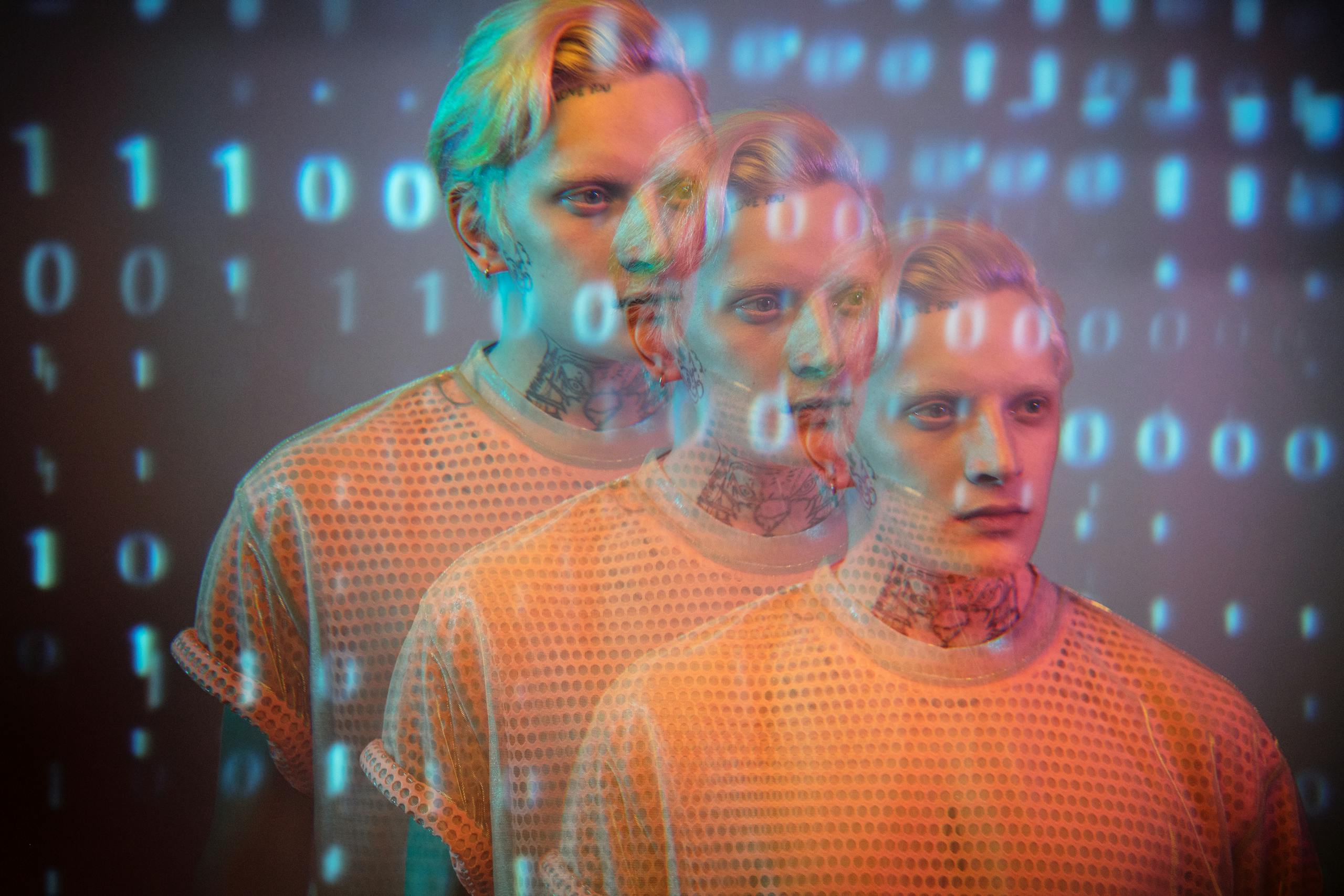 Multi-exposure portrait of man with binary code overlay creating futuristic digital aesthetic.