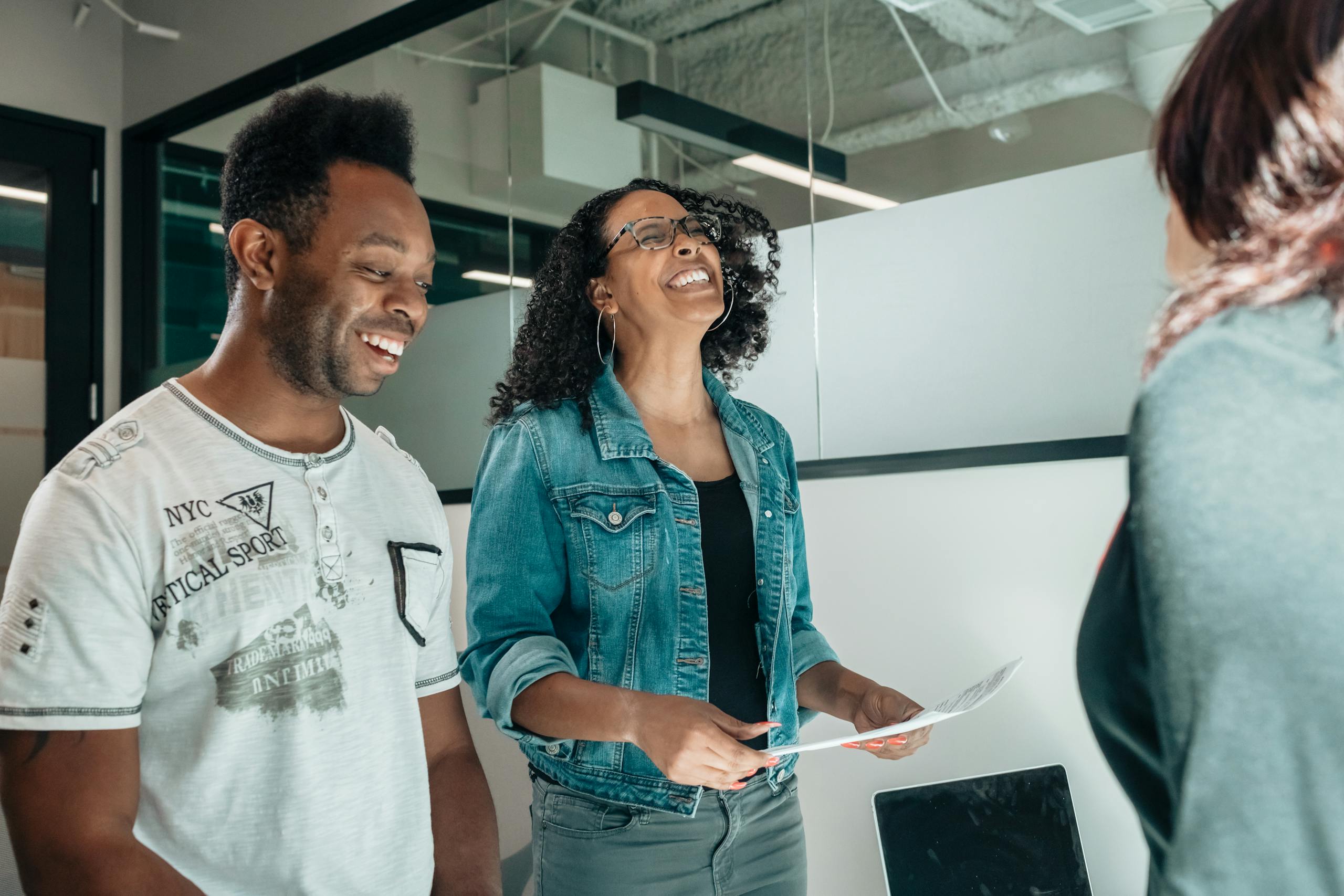 Smiling couple discussing with an advisor in a modern professional office setting.