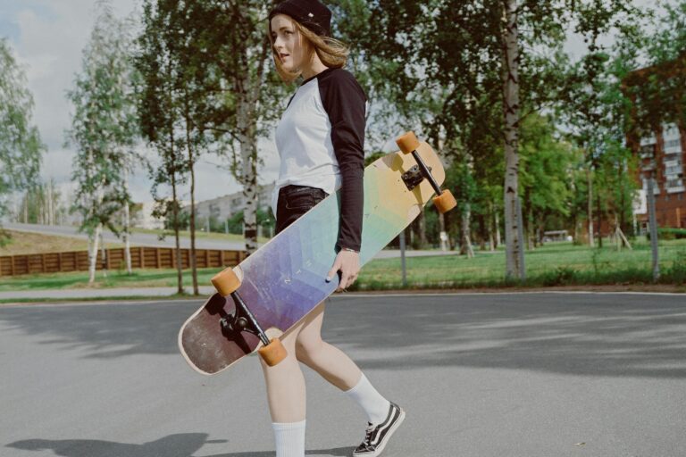 Teen girl carrying longboard skateboard in urban park enjoying outdoor leisure
