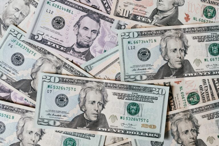 Top view of different colored American dollar bills stacked together