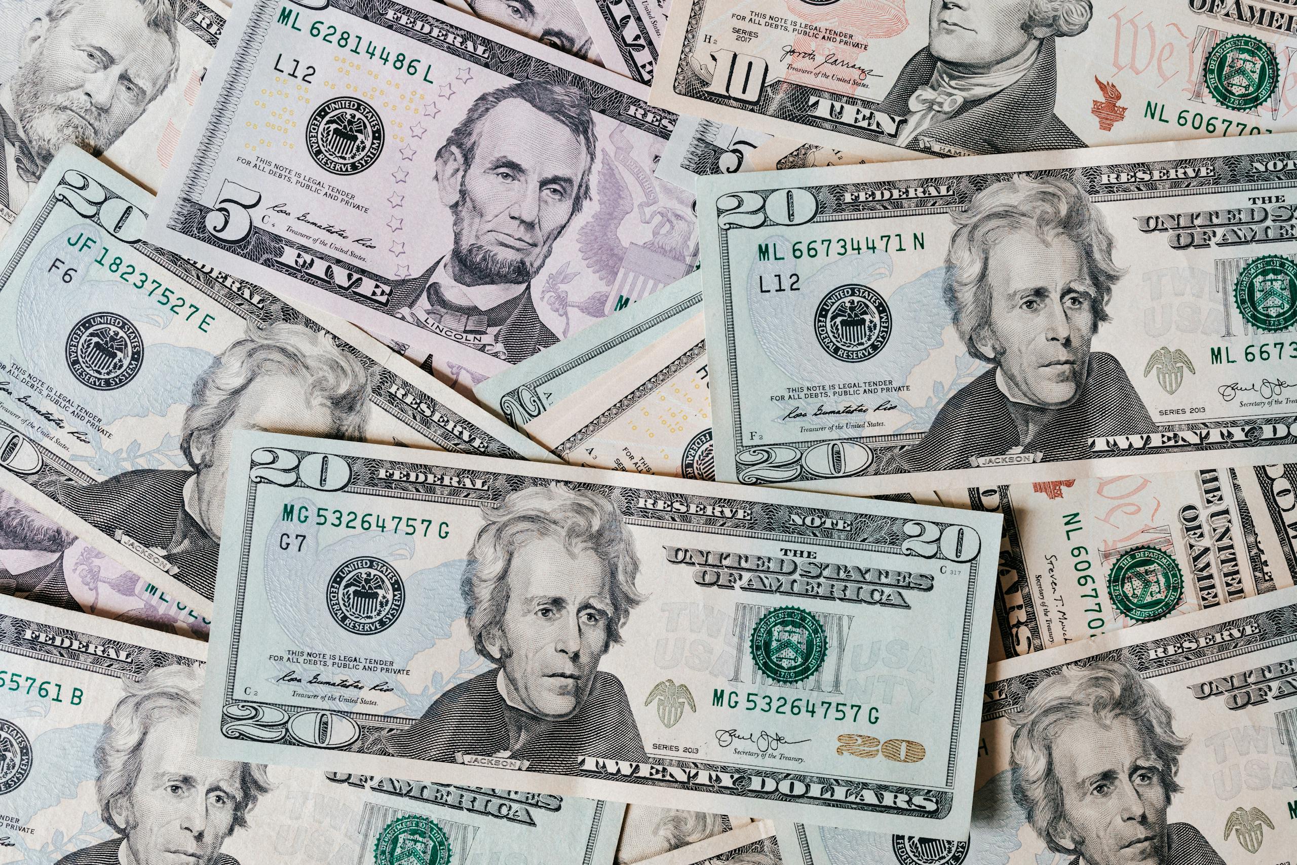 Top view of different colored American dollar bills stacked together