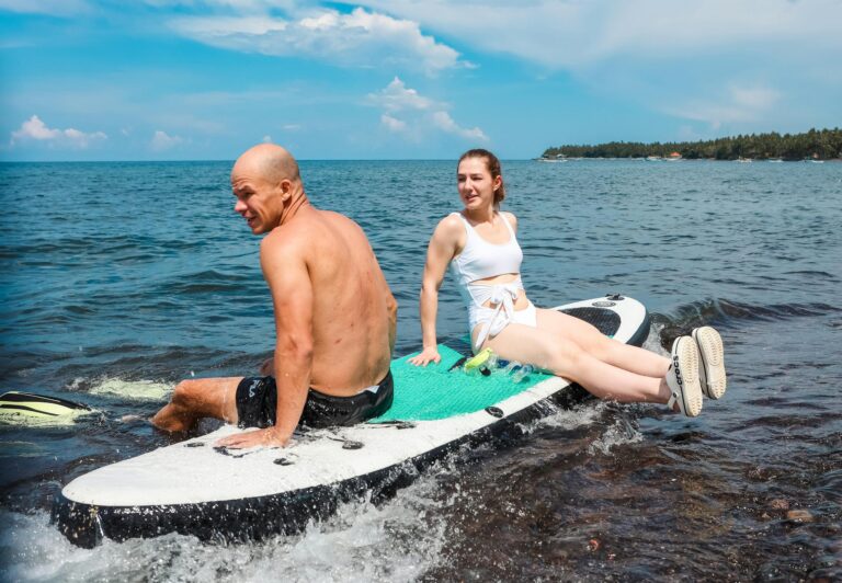 Two adventurous people laughing together during an exciting outdoor activity.