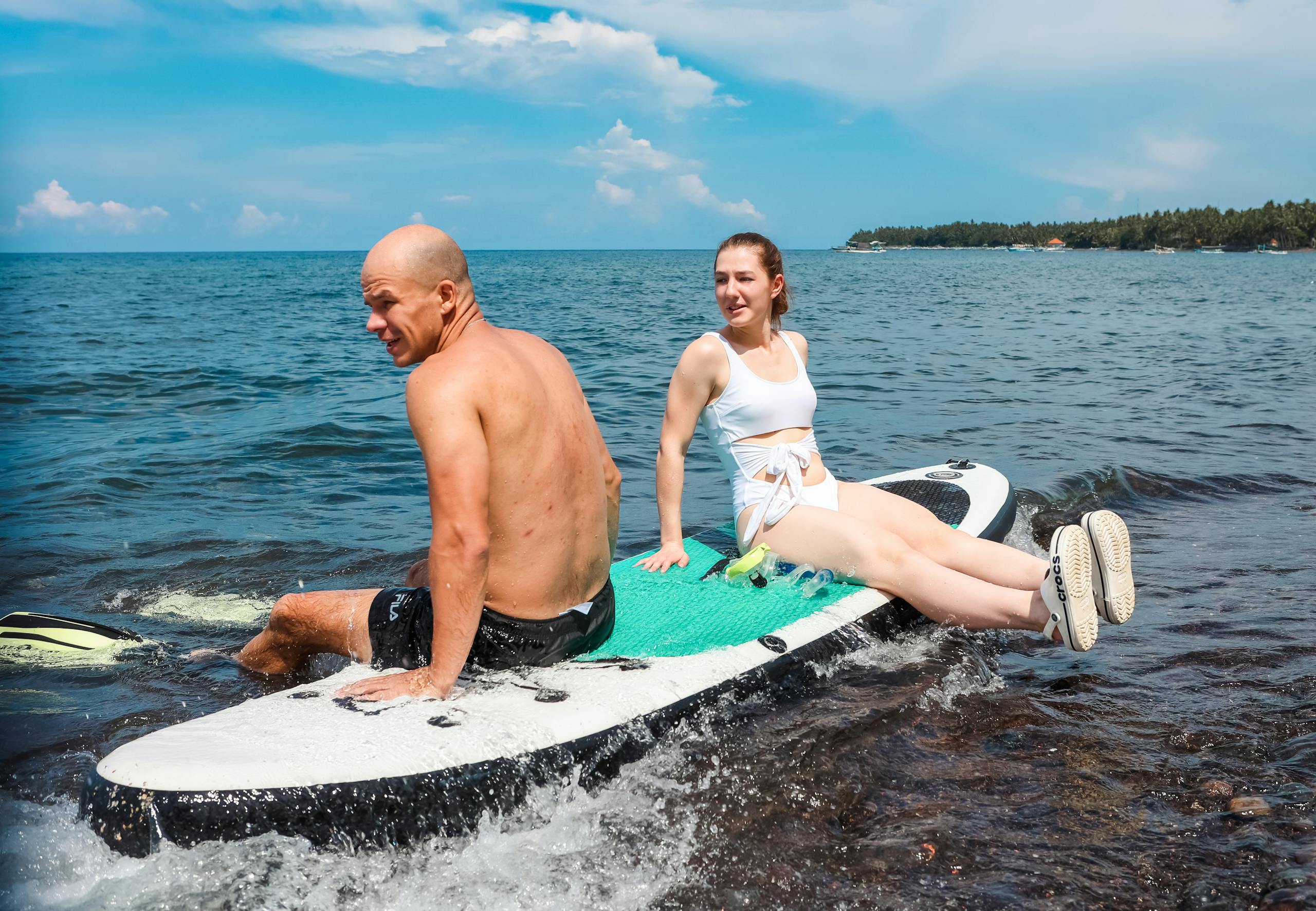 Two adventurous people laughing together during an exciting outdoor activity.