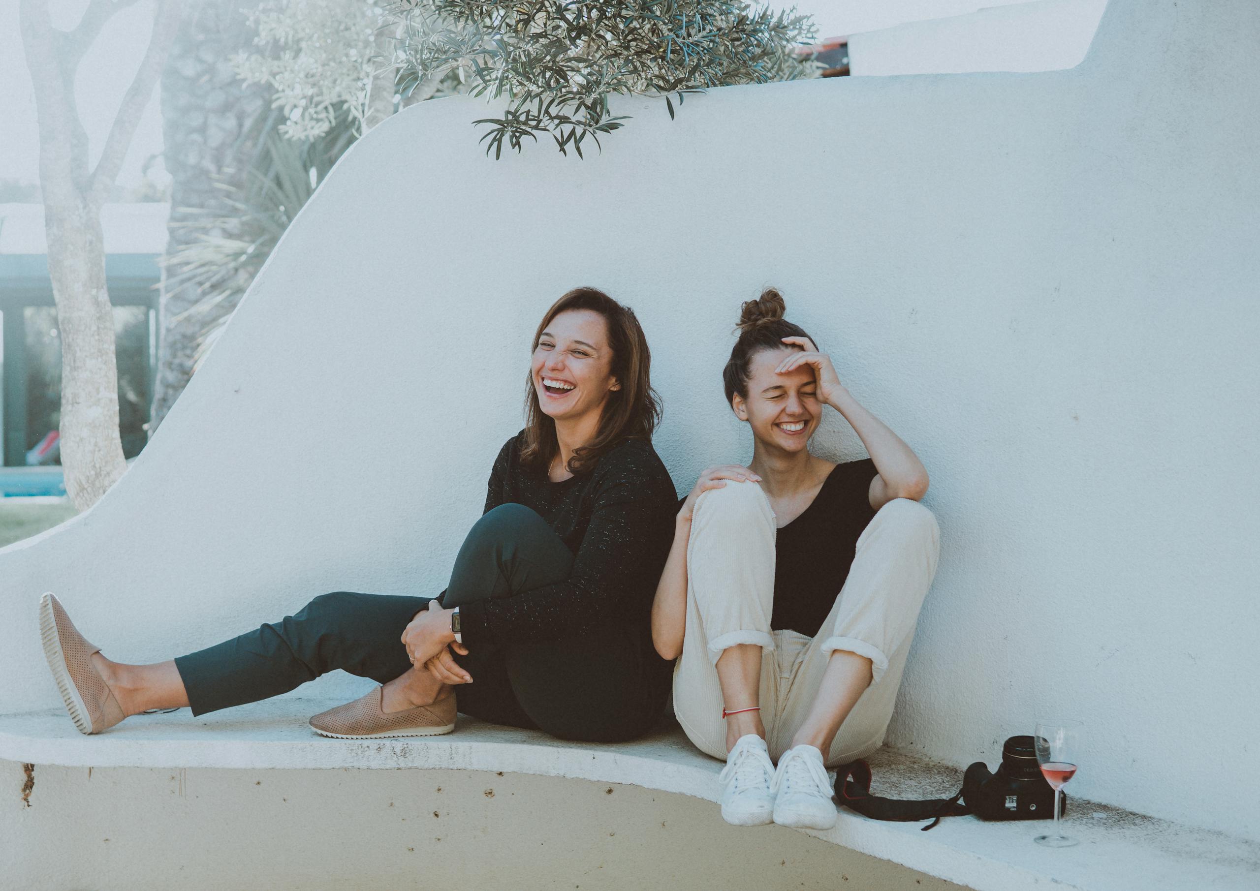 Two women laughing together outdoors enjoying friendship and leisure time