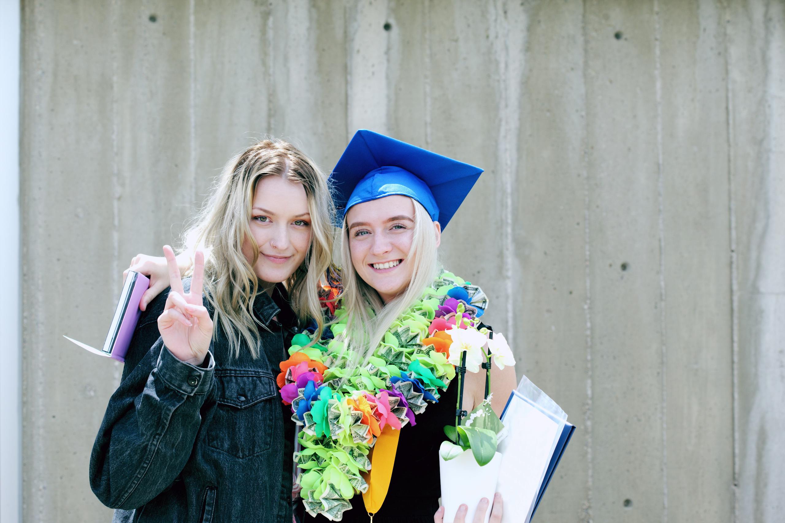 Two young women celebrating graduation outdoors with joy and vibrant colors