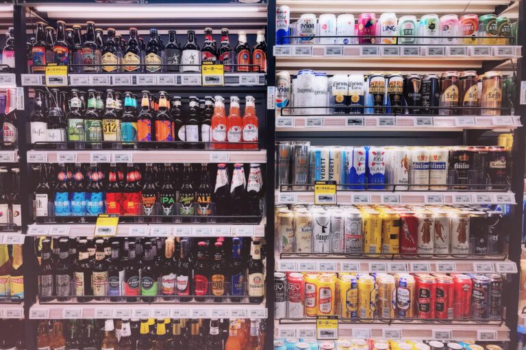 Wide variety of bottled and canned beers displayed on store shelves