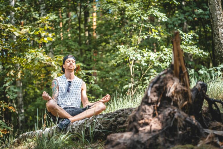 Young man meditating peacefully on wooden log in serene forest setting